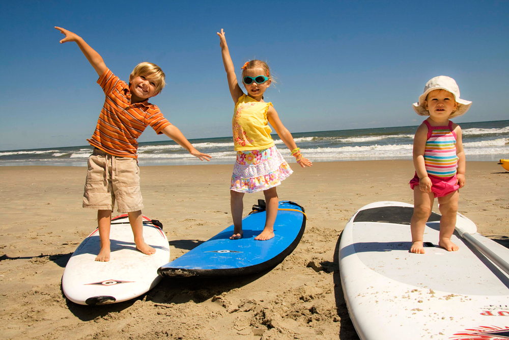 Young surfers on boards from Ocean Atlantic Rentals